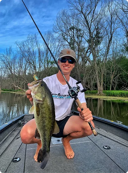 Captain Max holding a large bass on the boat